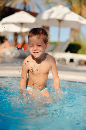 hot sunny day a boy swimming in the poolの写真素材