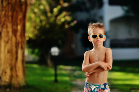 in the park outdoors only boy in shorts and sunglassesの写真素材