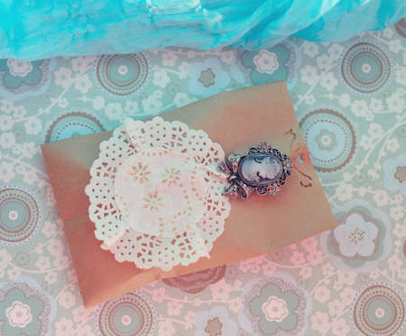 paper envelope on white cloth and delicate brooch with stonesの写真素材