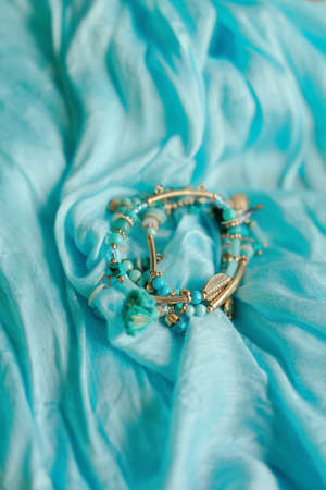 a blue scarf is feminine bracelet of small colored beadsの写真素材