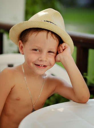 hot summer day poses little boy in straw hatの写真素材