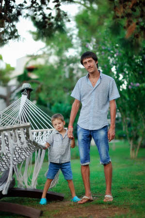 summer green park father and son are in a large hammockの写真素材