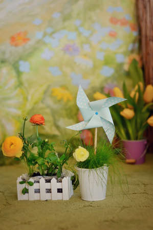 Spring composition of bouquets of flowers in vases and a toy pinwheel paperの写真素材