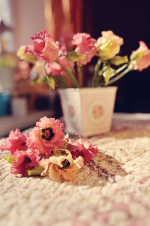 in the rays of sunlight on the windowsill vase with decorative flowers and lies next to a bouquet