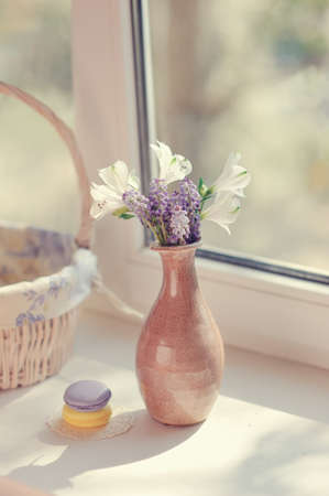 the sun on the window sill delicate bouquet in pink vaseの写真素材
