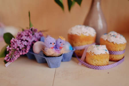 Easter composition, beautiful cakes with colored eggs and lilacの写真素材