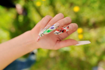 against the background of flowering branches of women s hands with a nice manicure different pictureの写真素材