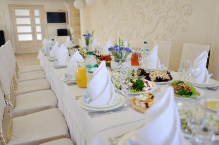 a beautifully decorated banquet table with white towels in a bright roomの写真素材