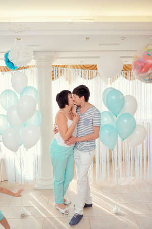 in the banquet hall of a young couple in a light suit on the background of balloonsの写真素材