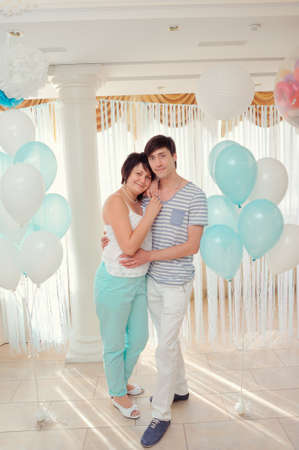 in the banquet hall of a young couple in a light suit on the background of balloonsの写真素材