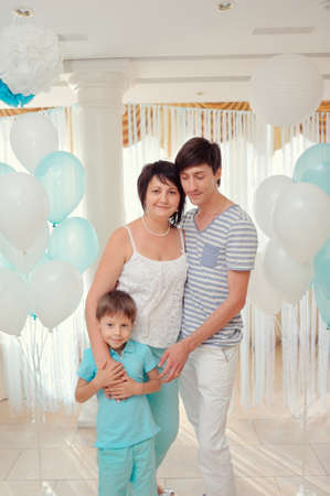 happy family in turquoise costumes against the backdrop of balloonsの写真素材