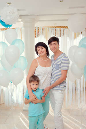 happy family in turquoise costumes against the backdrop of balloonsの写真素材