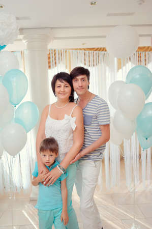 happy family in turquoise costumes against the backdrop of balloonsの写真素材