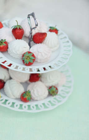 on a white background, the high vase with white and red strawberry marshmallowsの写真素材