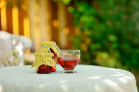on the nature of the banks on a white table with strawberry jam and a bowl of jam