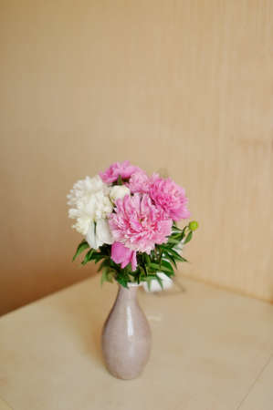 on the table in a vase bouquet of fluffy pink and white peoniesの写真素材