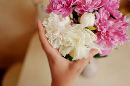 close-up of a hand bouquet of white and pink peoniesの写真素材