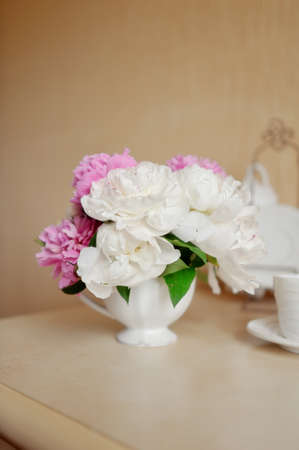 on a light background in white decorative vase pink and white peoniesの写真素材