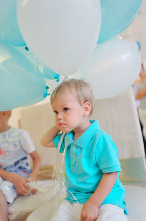 little boy in a blue jacket with big balloonsの写真素材