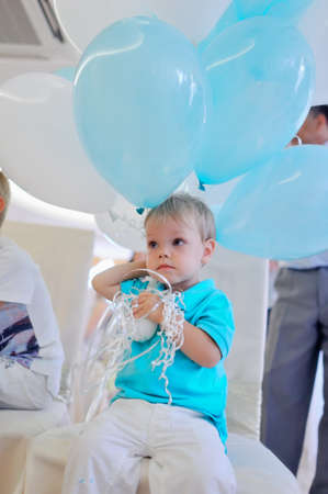 little boy in a blue jacket with big balloonsの写真素材