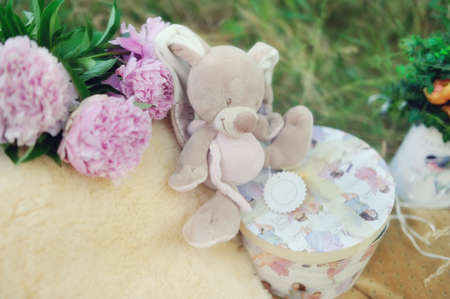 Outdoors in the grass beautiful box with a toy and a bouquet of peoniesの写真素材
