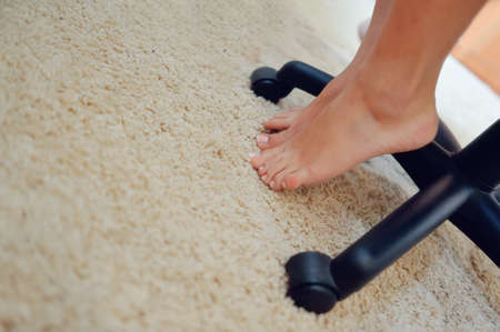 on the floor beside the chair female legs standing on toesの写真素材
