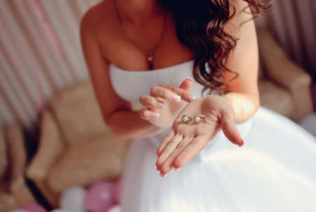 beautiful female hands with manicure holding bride s beautiful earringsの写真素材