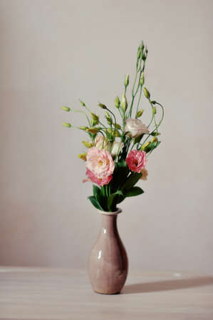on a light background elegant vase with a bouquet of pink flowersの写真素材
