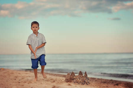 little boy on the beach was building a sand castleの写真素材