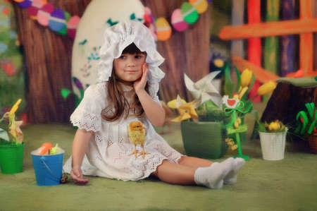 sitting on the floor of the Easter decorations lovely girl in a white dress and hatの写真素材