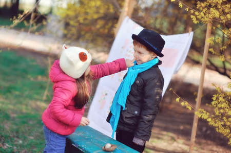 little girl with a boy playing together and having fun in natureの写真素材