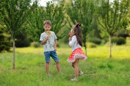 in the park on the lawn plays a girl in a suit of Mickey Mouse with a little boyの写真素材