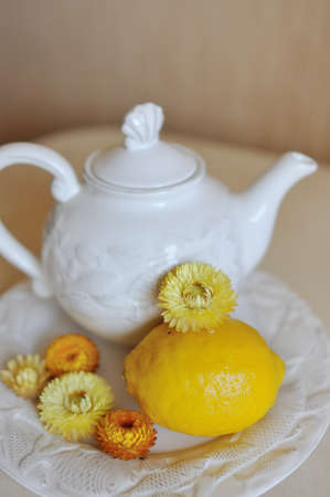 However beautiful white crockery, tea and saucer with lemon and flowersの写真素材