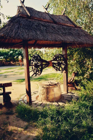 well under a thatched shed with wooden wheelsの写真素材