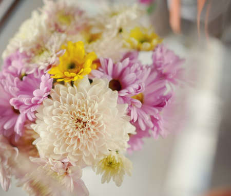 on the windowsill in a wet glass is white vase with a bouquet of flowersの写真素材