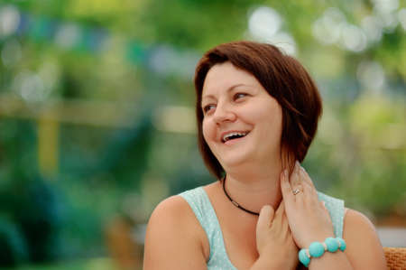 emotional portrait of a cheerful girl in a turquoise dress and a bracelet on his wristの写真素材