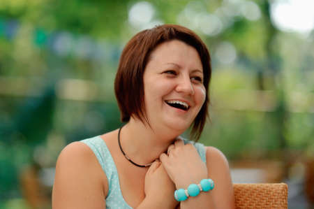 emotional portrait of a cheerful girl in a turquoise dress and a bracelet on his wristの写真素材