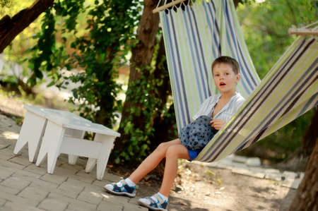in the park cute little boy swinging in a hammockの写真素材