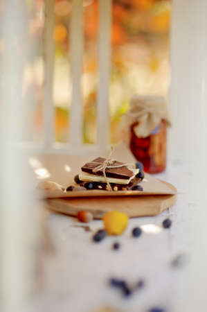 in the rays of sunlight on the white buffet jars of jam, berries and chocolateの写真素材