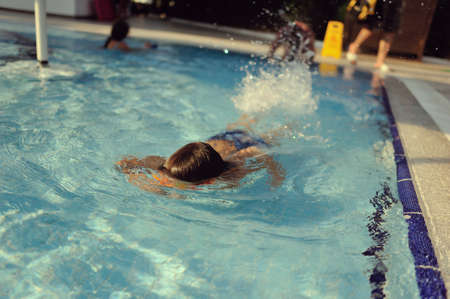 hot sunny day boy with glasses in the swimming poolの写真素材