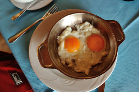 on a table on a white plate with pan fried eggsの写真素材