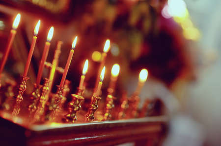 in the church on a gold candlestick burning wax candlesの写真素材