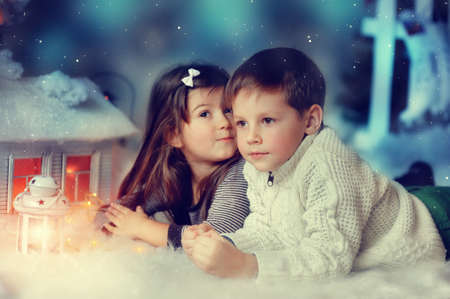 White Christmas fairy house with lights and cute little boy and girlの写真素材