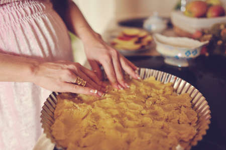 Pregnant woman in the kitchen preparing a delicious apple pie