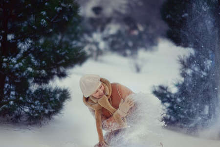 winter in the pine forest woman playing with snowの写真素材