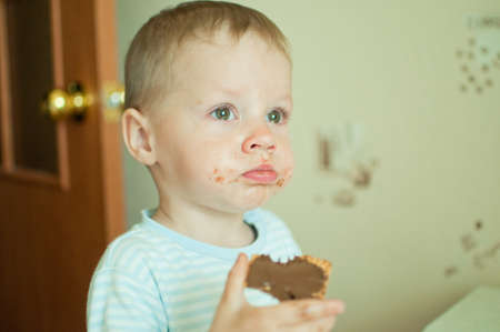 offended little boy tearfully eats chocolate dessertの写真素材