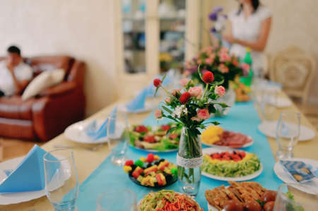 banquet table with a blue tablecloth and ornately decorated sandwichesの写真素材