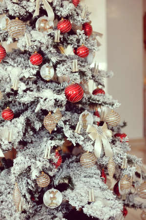 beautiful Christmas tree with snow on the branches and colored toysの写真素材