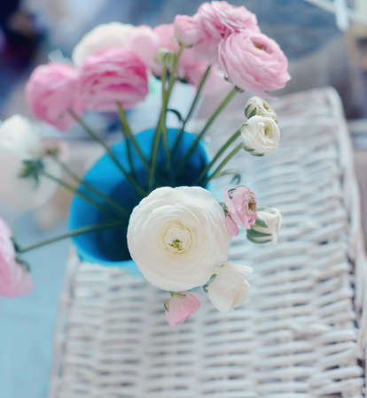 beautiful and delicate bouquet of buttercups in a blue bucket