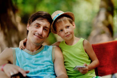Outdoors portrait of father and son in a straw hatの写真素材